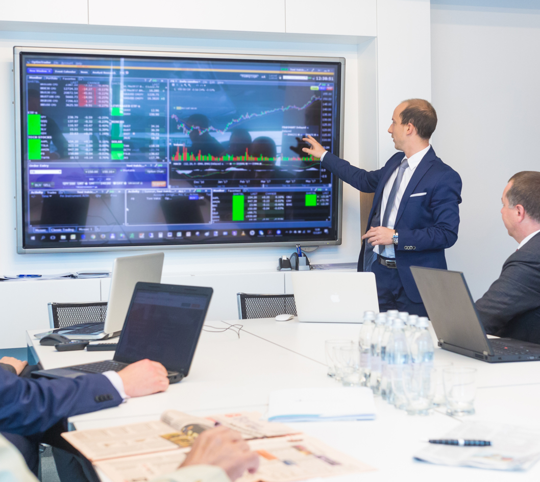 advisors reviewing market data on big screen